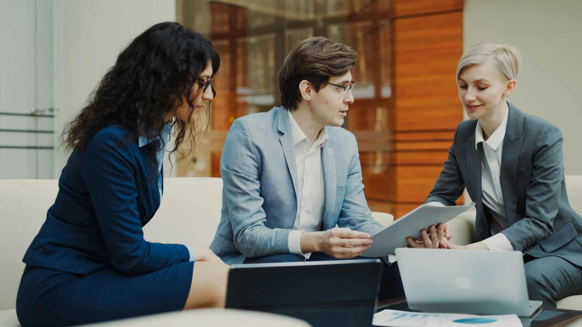 Three colleagues discussing documents at a table